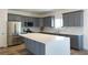 Stylish kitchen featuring gray cabinets, stainless steel appliances, and a large island with quartz countertops at 5400 E Grain Mill Rd, Pahrump, NV 89061