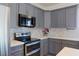 Kitchen boasting stylish gray cabinets, stainless steel appliances, and mosaic backsplash at 5400 E Grain Mill Rd, Pahrump, NV 89061