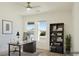 Staged home office with bright light, ceiling fan, neutral decor, and view out the windows at 5400 E Grain Mill Rd, Pahrump, NV 89061
