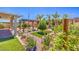 Serene backyard space with landscaping, brick pavers, mature trees, synthetic grass, and a pergola at 5429 Blinding Lights St, North Las Vegas, NV 89081