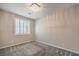 Well-lit bedroom with a stylish light fixture, carpet flooring, and a window at 5429 Blinding Lights St, North Las Vegas, NV 89081