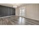 Spacious bedroom with dark accent wall, gray wood floors, and double doors to patio at 5429 Blinding Lights St, North Las Vegas, NV 89081