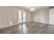 Spacious bedroom with gray wood floors, chandelier and double doors to patio at 5429 Blinding Lights St, North Las Vegas, NV 89081
