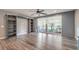 Bright living room with grey hardwood floors, ceiling fan, built-in shelves, and a sliding glass door at 5429 Blinding Lights St, North Las Vegas, NV 89081