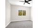 Light-filled bedroom featuring a modern ceiling fan, carpeted floors, and backyard views at 5655 E Sahara Ave # 2009, Las Vegas, NV 89142