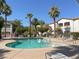Community pool and lounge chairs surrounded by lush trees and landscaping at 5655 E Sahara Ave # 2009, Las Vegas, NV 89142