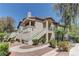 This is a tan two-story home with green bushes and trees in front at 5710 E Tropicana Ave # 1216, Las Vegas, NV 89122