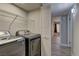 This laundry room offers modern washer and dryer with wire shelving at 5710 E Tropicana Ave # 1216, Las Vegas, NV 89122