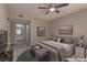 Comfortable bedroom featuring a ceiling fan, neutral walls, and access to the bathroom with a vanity sink at 5710 E Tropicana Ave # 1216, Las Vegas, NV 89122