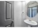 A well-lit powder room showcases a modern sink and vanity with a round mirror and convenient towel rack at 5740 Winter Cherry St, Las Vegas, NV 89130