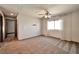 Bright, carpeted bedroom featuring a window, ceiling fan, and neutral walls, with convenient access to hallway at 5740 Winter Cherry St, Las Vegas, NV 89130