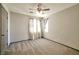 A bright and airy bedroom with neutral walls and plush carpet, featuring a ceiling fan and natural light at 5740 Winter Cherry St, Las Vegas, NV 89130