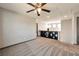 Carpeted bonus room includes bar with shelving and mini fridge, and a ceiling fan at 5740 Winter Cherry St, Las Vegas, NV 89130