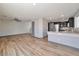 Open-concept living area with wood-look flooring, seamlessly connected to the kitchen with dark cabinetry and light countertops at 5740 Winter Cherry St, Las Vegas, NV 89130