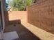 Private backyard featuring rock landscaping, enclosed by a brick wall, and a small concrete patio at 6255 W Arby Ave # 239, Las Vegas, NV 89118