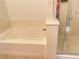 Bathroom showcasing a soaking tub with a shower and a glass door at 6255 W Arby Ave # 239, Las Vegas, NV 89118