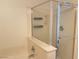 Shower featuring glass doors, built-in shelving, and modern fixtures at 6255 W Arby Ave # 239, Las Vegas, NV 89118