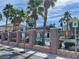 Inviting community pool area with palm trees, lounge chairs, umbrellas, and accessible reserved parking spots at 6255 W Arby Ave # 239, Las Vegas, NV 89118