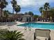 Inviting community pool area with palm trees, lounge chairs, and a clubhouse at 6255 W Arby Ave # 239, Las Vegas, NV 89118