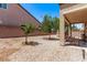 Rock landscaped backyard with mature trees and covered patio at 6617 Johnny Love Ln, North Las Vegas, NV 89086