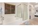 Bright bathroom featuring tub, separate glass shower, and a window with blinds for privacy at 6617 Johnny Love Ln, North Las Vegas, NV 89086