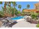 Backyard features a sparkling pool, well-maintained landscaping, and an umbrella shaded seating area at 7301 Heggie Ave, Las Vegas, NV 89131