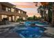 Resort-style backyard featuring a beautiful pool, spa, rock features, and lush landscaping at 7301 Heggie Ave, Las Vegas, NV 89131