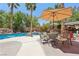 Inviting backyard pool with rock waterfall, covered patio bar and tall palm trees for a tropical oasis at 7301 Heggie Ave, Las Vegas, NV 89131