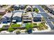 An aerial view of the backyard, neighborhood, and street with well-manicured lawns, solar panels, and a gated entry at 7322 Columbia Rock Ct, Las Vegas, NV 89178