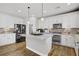 Modern kitchen features white cabinetry, stainless steel appliances, granite countertops and hardwood floors at 7322 Columbia Rock Ct, Las Vegas, NV 89178