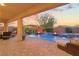 Inviting outdoor area showcases a shimmering pool, patio, comfortable seating, and sunset sky at 7322 Columbia Rock Ct, Las Vegas, NV 89178