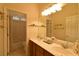Bright bathroom with double sinks, tiled floor, shower, and bath with white cabinets at 7325 Rustic Crest St, Las Vegas, NV 89149