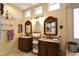 Lavish bathroom featuring dual sinks, dark wood cabinets, elegant lighting fixtures and custom towel storage at 7325 Rustic Crest St, Las Vegas, NV 89149