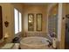 A stylish bathtub is adorned with two decorative mirrors and enhanced by adjacent decorative glass shower panels at 7325 Rustic Crest St, Las Vegas, NV 89149