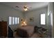 Well-lit bedroom with shutters, TV, dresser, art pieces, and relaxing chair at 7325 Rustic Crest St, Las Vegas, NV 89149
