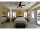 Light filled main bedroom featuring a ceiling fan, plantation shutters, and sliding glass door access to the pool at 7325 Rustic Crest St, Las Vegas, NV 89149