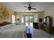 Bright main bedroom with white bedding, ceiling fan, and doors opening to a pool area at 7325 Rustic Crest St, Las Vegas, NV 89149