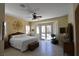 Spacious main bedroom with a ceiling fan, white bedding, and doors to the outdoor pool at 7325 Rustic Crest St, Las Vegas, NV 89149