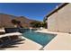 Backyard pool with a stone privacy wall and desert landscaping at 7325 Rustic Crest St, Las Vegas, NV 89149