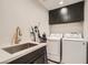 Bright laundry room features a sink, modern washer and dryer, and ample cabinet space for storage at 778 Vegas Valley Dr, Las Vegas, NV 89109