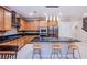 Modern kitchen featuring a central island with seating, stainless steel appliances, and warm wood cabinetry at 8021 Adelaide Hills St, Las Vegas, NV 89113