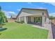 View of the backyard with artificial lawn, covered patio, and landscaped gardens at 8405 Canyon Crevasse St, Las Vegas, NV 89166