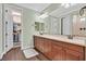 Bright bathroom featuring dual sinks, wood cabinets, walk-in closet and wood flooring at 8405 Canyon Crevasse St, Las Vegas, NV 89166