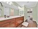 Bright bathroom with dual sinks, wood cabinets and wood-look flooring at 8405 Canyon Crevasse St, Las Vegas, NV 89166