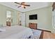 Comfortable bedroom with wood floors, ceiling fan and a dresser under a wall-mounted TV at 8405 Canyon Crevasse St, Las Vegas, NV 89166