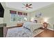 Cozy bedroom with a ceiling fan, wood floors, and windows with a view at 8405 Canyon Crevasse St, Las Vegas, NV 89166