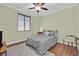 Bedroom with wood floors, ceiling fan, window with blinds, and a gray comforter at 8405 Canyon Crevasse St, Las Vegas, NV 89166
