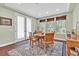 Bright dining room featuring wood floors, a round table, and double doors at 8405 Canyon Crevasse St, Las Vegas, NV 89166