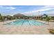Large community pool with clear blue water, lounge chairs, and umbrellas for relaxation by the water at 8405 Canyon Crevasse St, Las Vegas, NV 89166