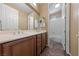 Double vanity bathroom with warm colored cabinets, two mirrors, and a tiled tub/shower at 8547 Benidorm Ave, Las Vegas, NV 89178